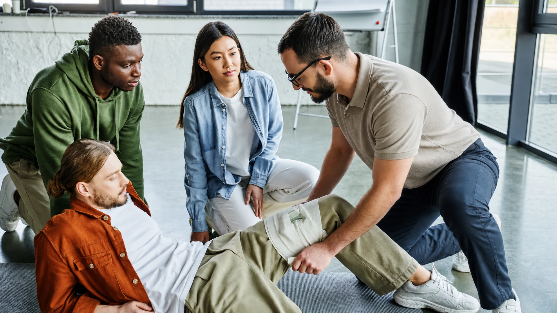 Formateur en tenue professionnelle démontrant la réanimation cardiopulmonaire sur un mannequin d'entraînement realiste à buste complet, les mains positionnées sur le thorax du mannequin pour effectuer le massage cardiaque. Salle de formation intérieure bien éclairée. Image de profil ou trois-quarts montrant clairement le geste technique et l'engagement du formateur.